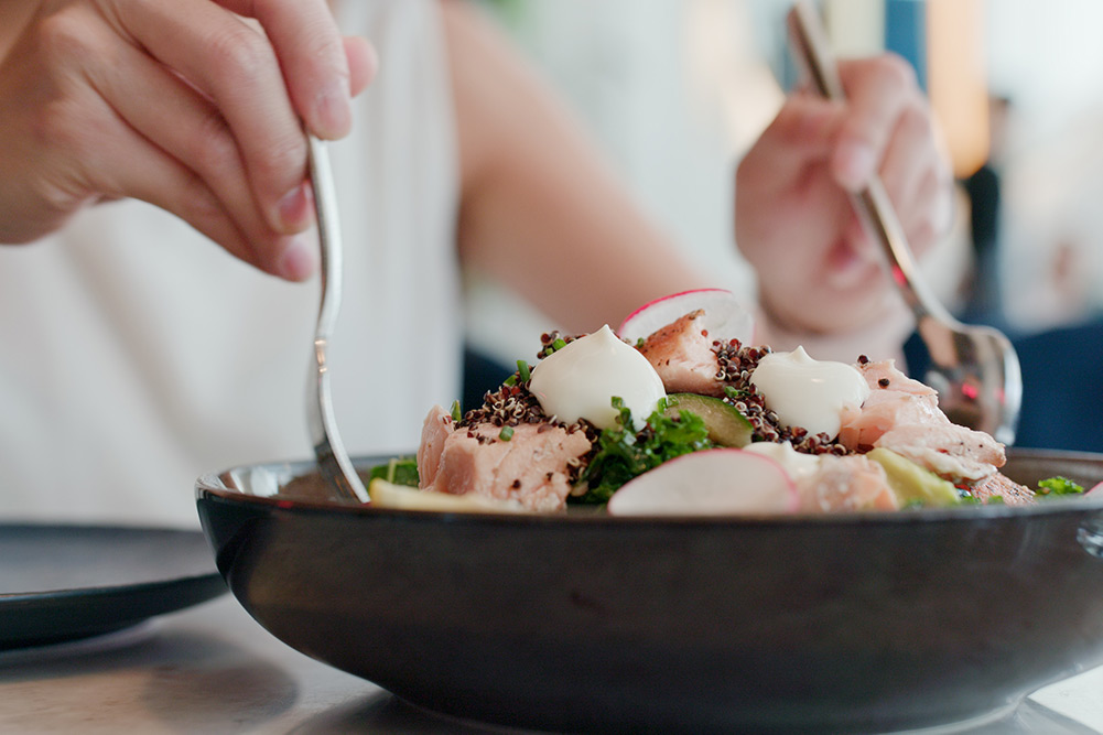 Close up of woman mixing bowl of healthy food