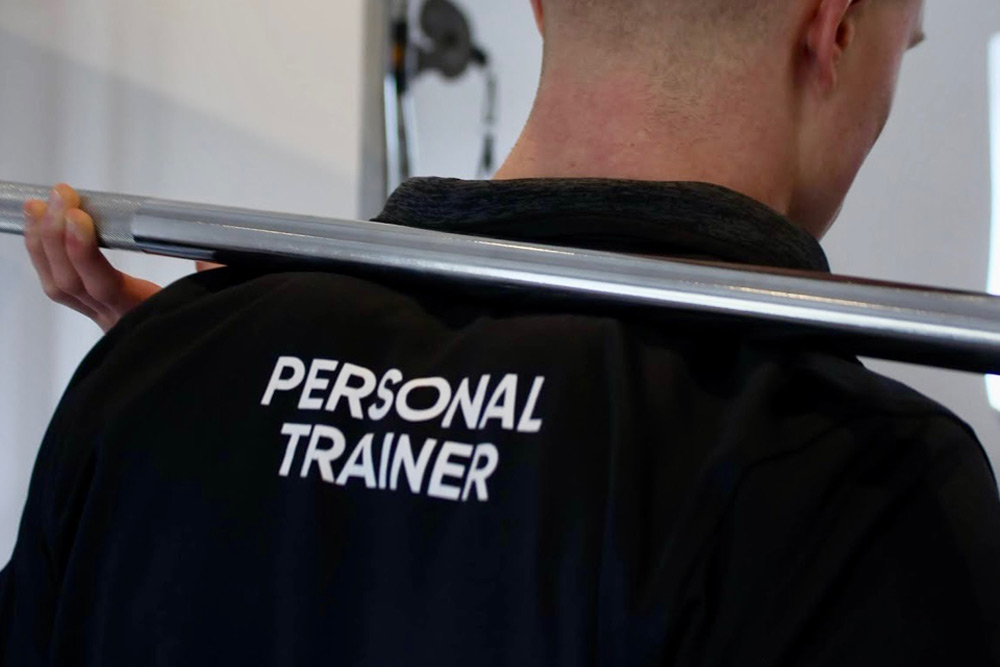 Close up of man wearing personal trainer labelled shirt